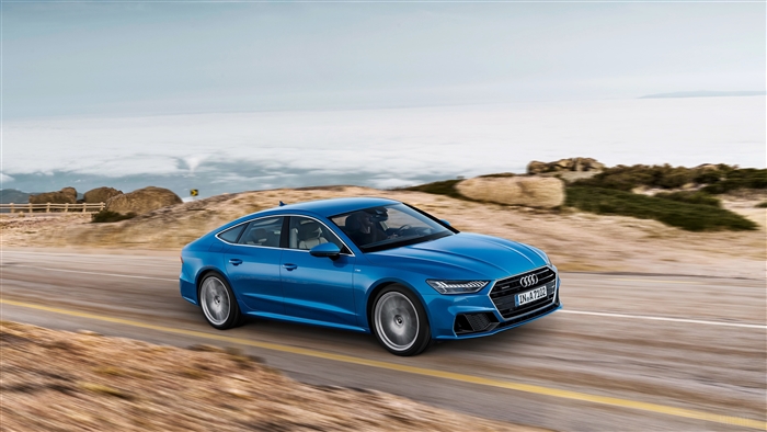 Blue Audi A7 Sportback driving on a scenic road
