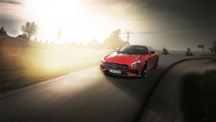 Red Mercedes AMG GTS driving on a winding road