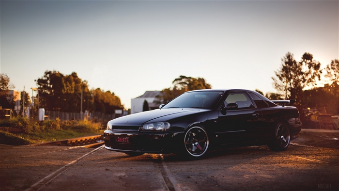 Black Nissan Skyline R34 GTR on Railroad Tracks