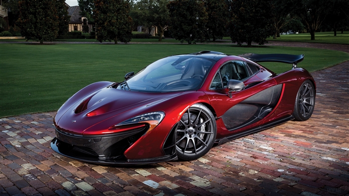 Red McLaren P1 sports car on a brick driveway