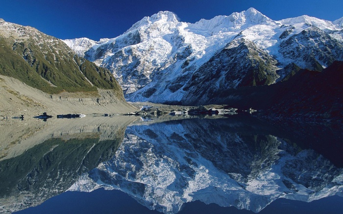 Snow-capped mountains reflected in a calm lake