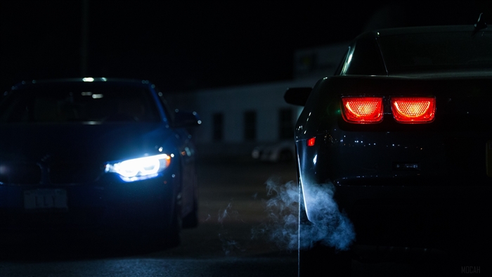 Two cars at night with lights on