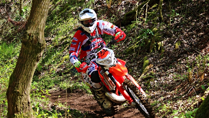 Motocross rider on a dirt track in a forest