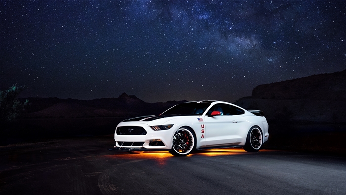 White Ford Mustang with USA flag at night