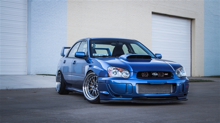 Blue Subaru Impreza WRX STI in front of a garage