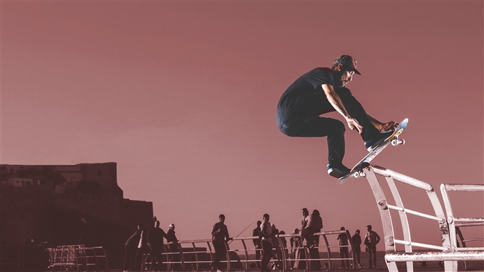 Skateboarder performing a trick over a railing