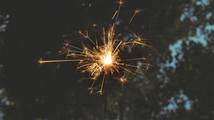 Sparkler with sparks and bokeh background