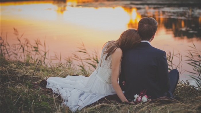 Newlyweds Couple Sitting by Lake at Sunset 4K