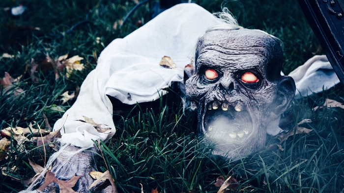 Scary Halloween zombie mask with glowing eyes in grass 4K