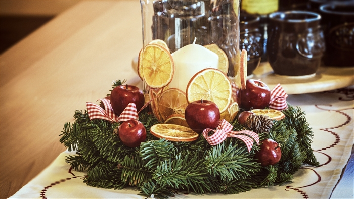 Christmas wreath with apples, oranges, and candle
