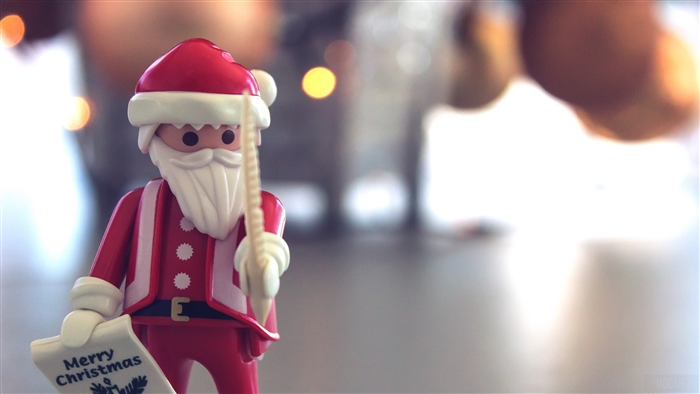 Playmobil Santa Claus toy holding Merry Christmas scroll