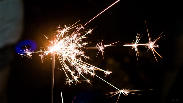 Sparkler with bright sparks and bokeh in 4K