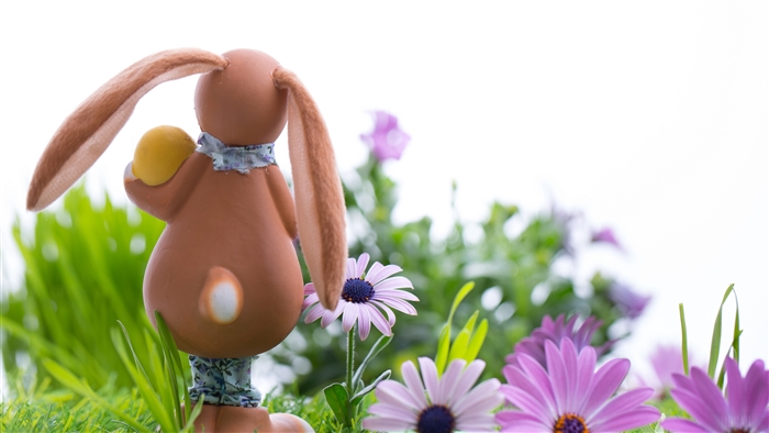 Easter bunny with egg in grass 4K