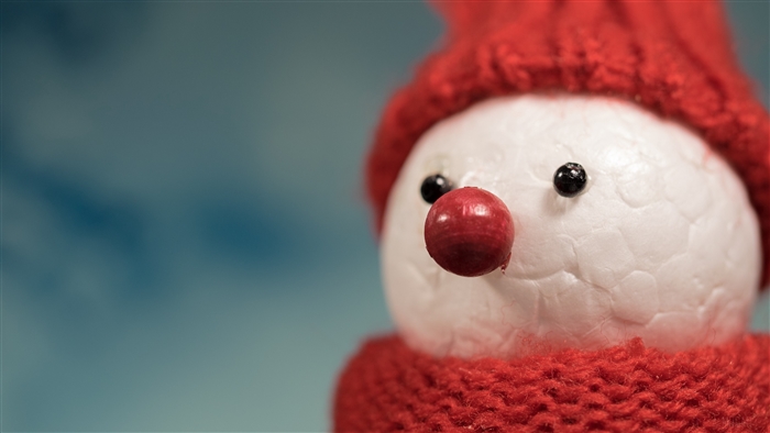 Close-up of a snowman figure with a red hat and scarf