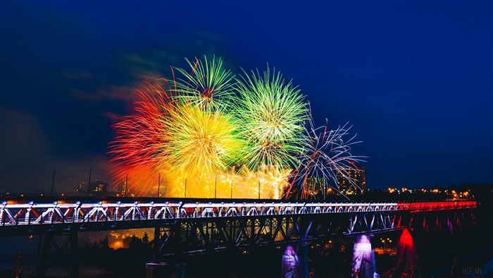 Colorful fireworks over a bridge at night