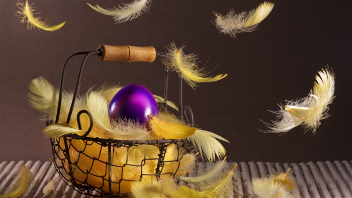 Purple Easter egg in a basket with yellow feathers 4K