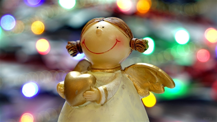 Angel statue holding a heart with bokeh lights
