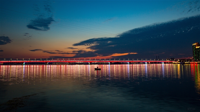 Bridge with lights over water at night