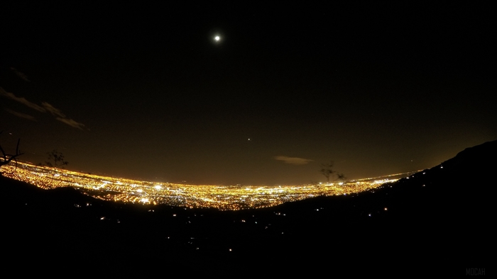 City lights at night with moon and planet