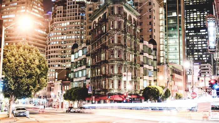 Cityscape at Night with Tall Buildings and Traffic