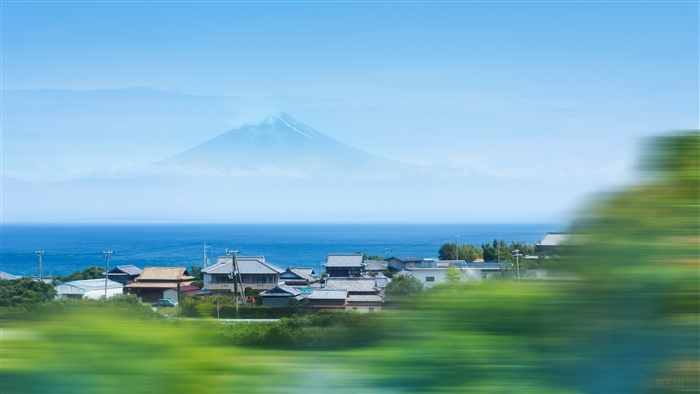 Mount Fuji over coastal village with motion blur