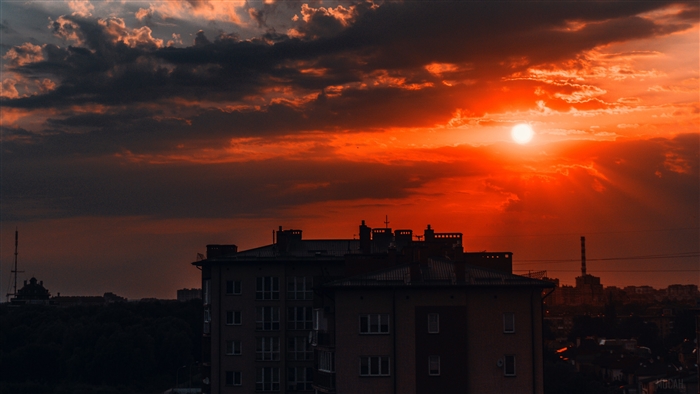 Sunset over buildings with dramatic clouds