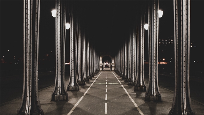 Bridge walkway at night with columns and lights