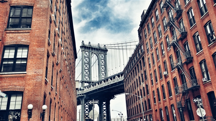 Manhattan Bridge between brick buildings 4K