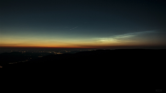 Noctilucent clouds over a city at night