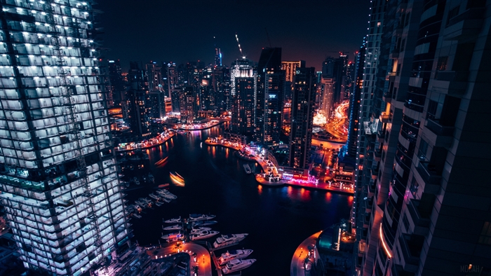Night city skyline with illuminated skyscrapers and marina