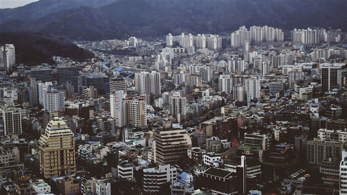 Cityscape with numerous buildings and mountains in the background, top view 4K