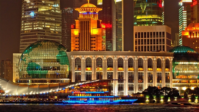 Shanghai skyscrapers at night with a boat