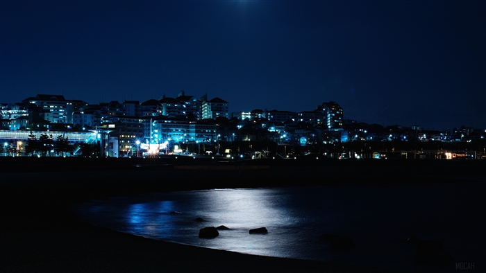 Night city skyline over the sea