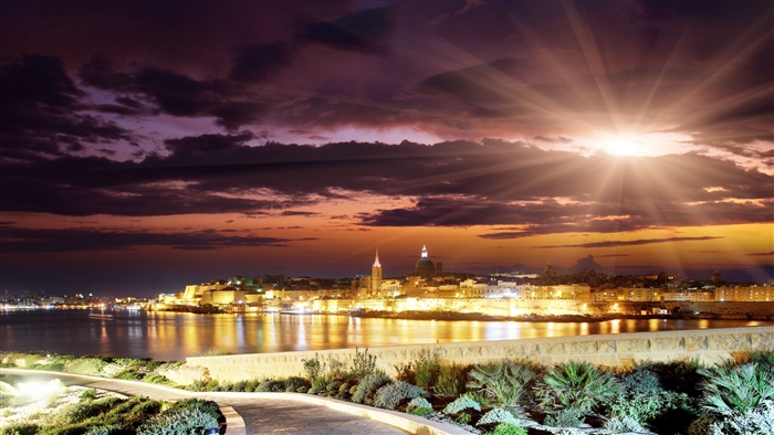 City skyline at sunset with sun rays