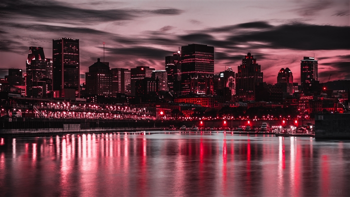 Night city skyline with red lights and water reflection