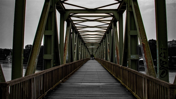 Green metal truss bridge over water
