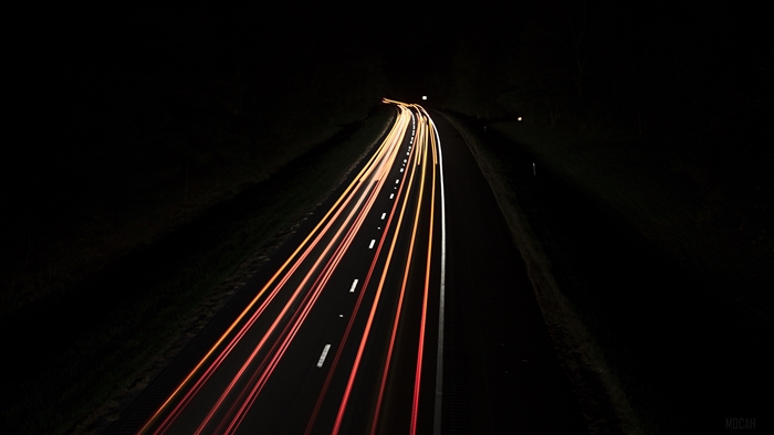 Light trails on a dark road at night