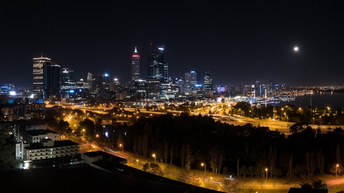 Night city skyline with skyscrapers and moon