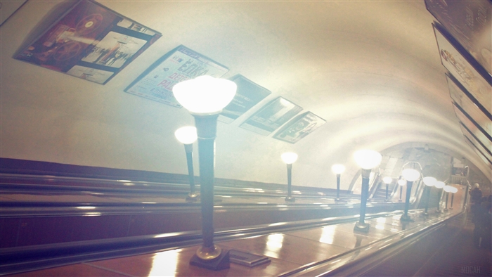 Subway escalator with posters and lamps