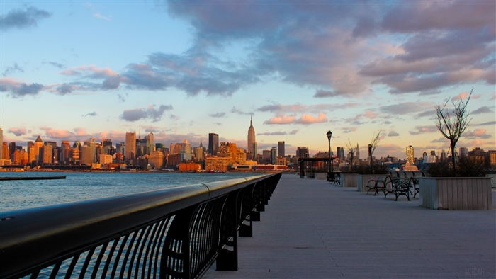 New York City skyline at sunset from an embankment