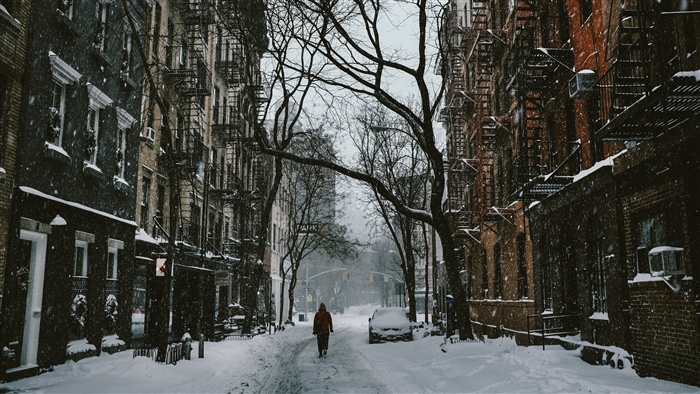 Person walking down a snowy city street in winter