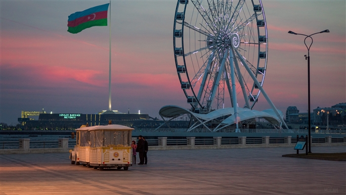 Azerbaijan flag and Ferris wheel at sunset