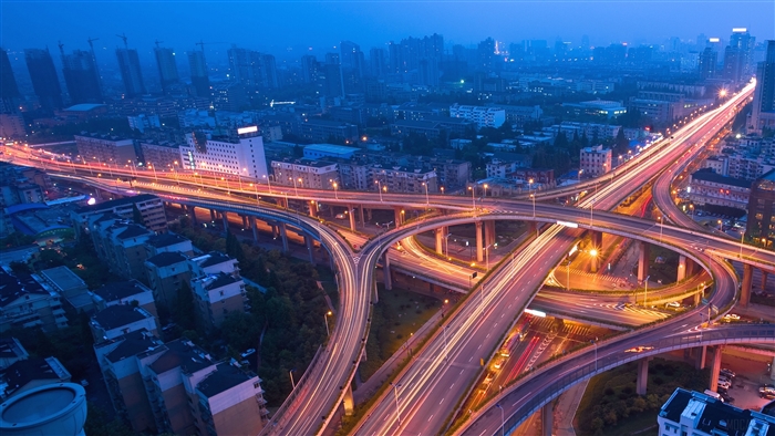 Night city flyover with traffic light trails 4K