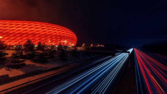 Allianz Arena stadium at night with light trails on highway