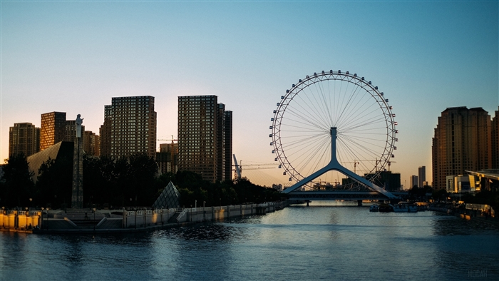 Ferris wheel and city skyline at sunset 4K