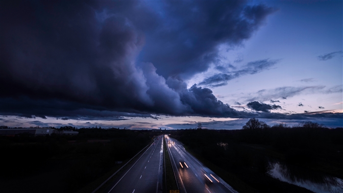 Stormy clouds over a highway with car light trails