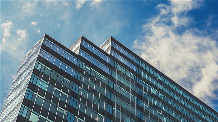 Modern glass building against a cloudy sky