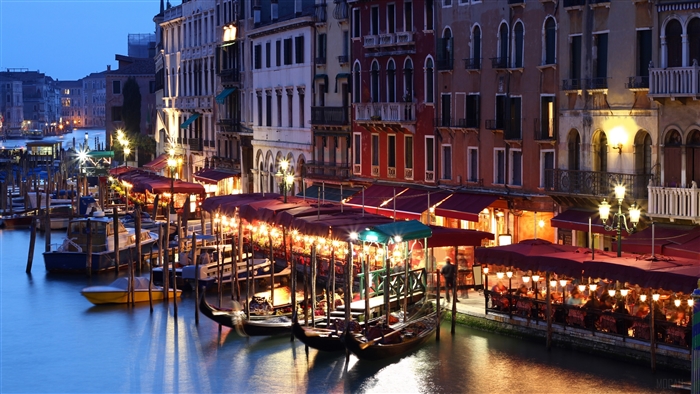 Venice canal with gondolas and cafes at dusk 4K
