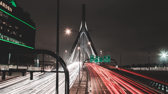 Night highway traffic on a bridge with city lights