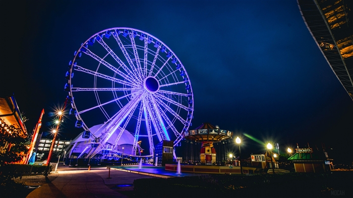 Ferris wheel attraction at night with blue lights